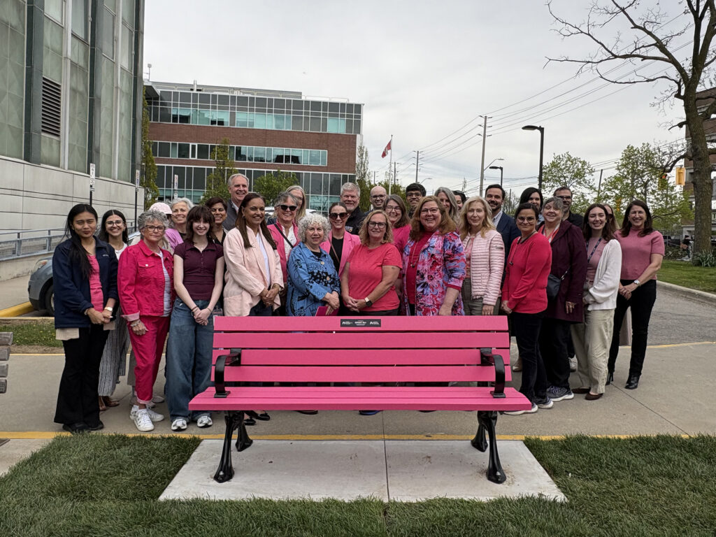 Group of BRIGHT Run organizers, supporters and healthcare staff gathered behind a bright pink commemorative bench outside Juravinski Hospital and Cancer Centre in honour of the community event’s support for breast cancer research.