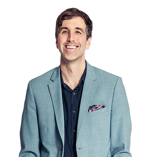 Man in a light blue suit and dark shirt